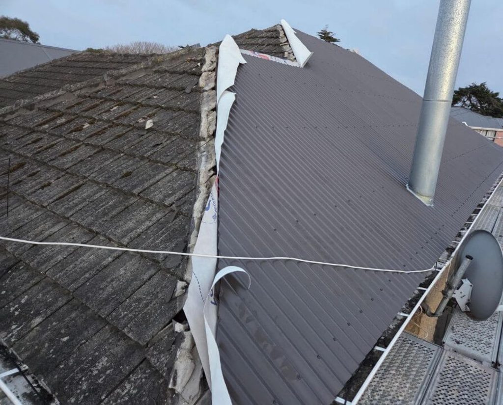Roof stripped with new metal roofing sheets being laid